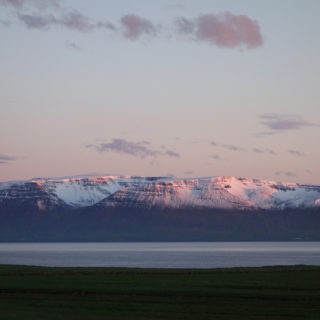 Snow capped mountains glowing at midnight