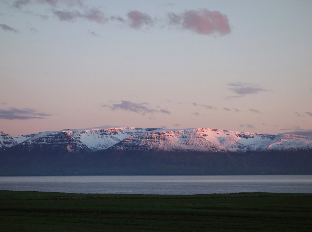 Snow capped mountains glowing at midnight